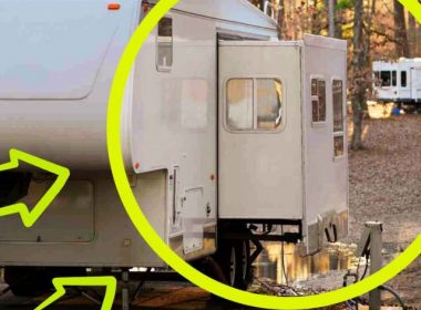A fifth wheel with its slide extended in a campground.
