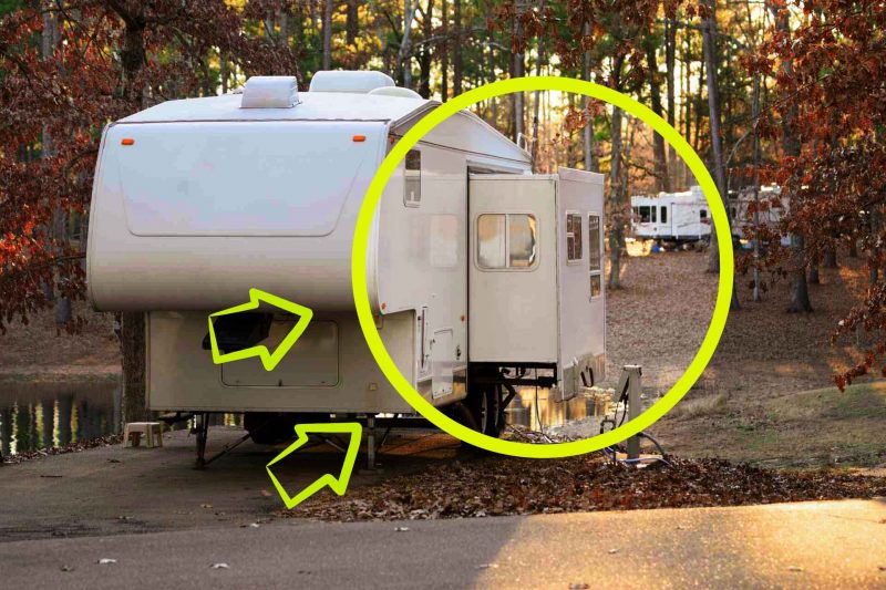 A fifth wheel with its slide extended in a campground.