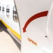 An airplane door open, showing a big red arrow.