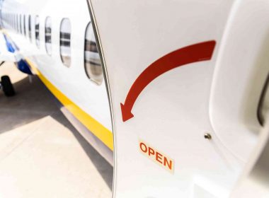 An airplane door open, showing a big red arrow.