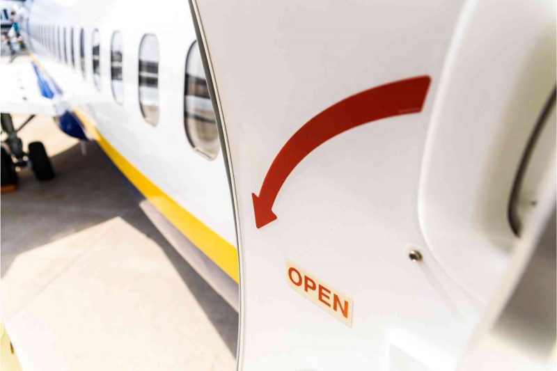 An airplane door open, showing a big red arrow.