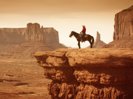 Cowboy on horse over rocky cliffs