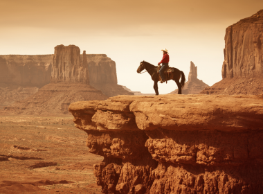 Cowboy on horse over rocky cliffs