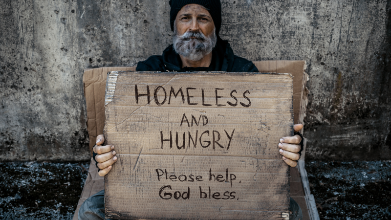 Homeless man holding sign