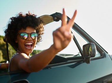 Woman happily driving on a road trip