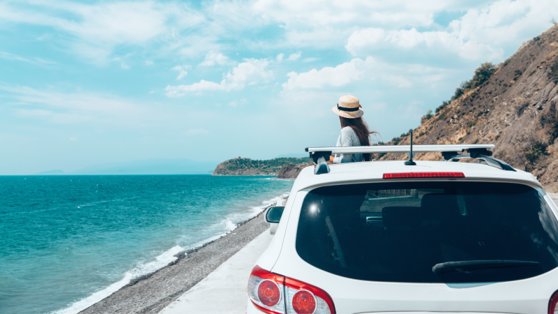 Woman in car on a road trip along the coast