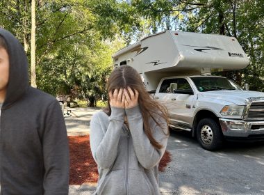 A couple fighting while standing outside of their RV.