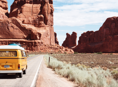 A camper van driving down the highway during a road trip.
