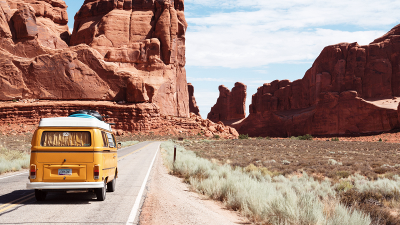 A camper van driving down the highway during a road trip.
