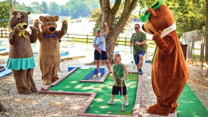 Yogi Bear and friends playing mini golf at a Jellystone campground