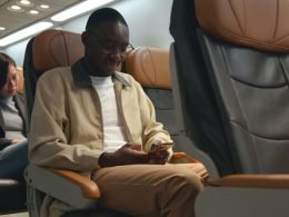 man using his phone not in airplane mode while flying