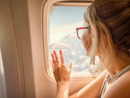Woman looking out window on an airplane.
