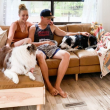 The couple from WIld RV life enjoying time on their couch with their dogs inside their RV.