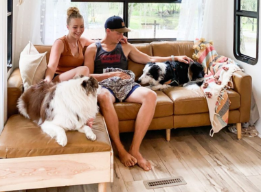 The couple from WIld RV life enjoying time on their couch with their dogs inside their RV.