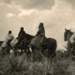 Four Apache on horseback on horseback under storm clouds. photo by Edward S. Curtis, 1906