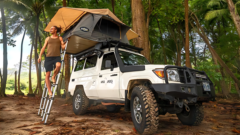 Fun for Louis climbing up a ladder to his truck tent above his truck in a tropical destination.