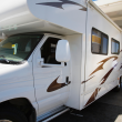 A person filling up their motorhome with gas at a gas pump.