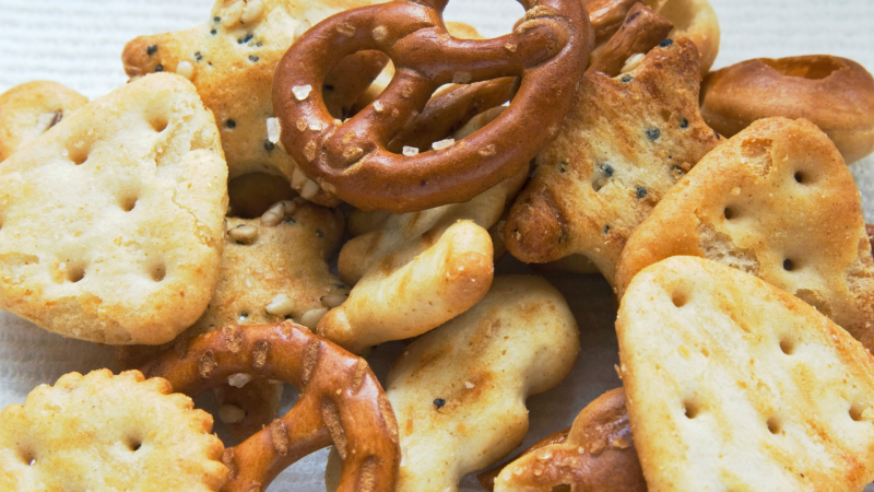 Snack mix of crackers and pretzels against a white background.