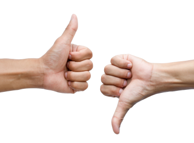 Two hands, one with their thumb up and the other with their thumb down on a white background.