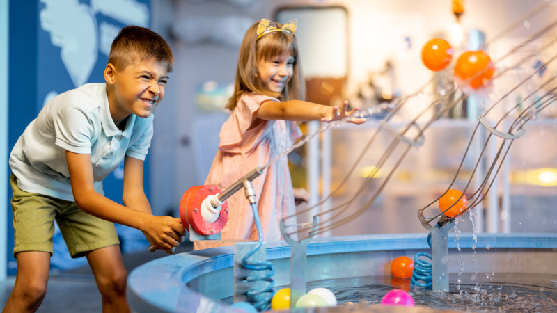 Two kids playing at an interactive science museum.