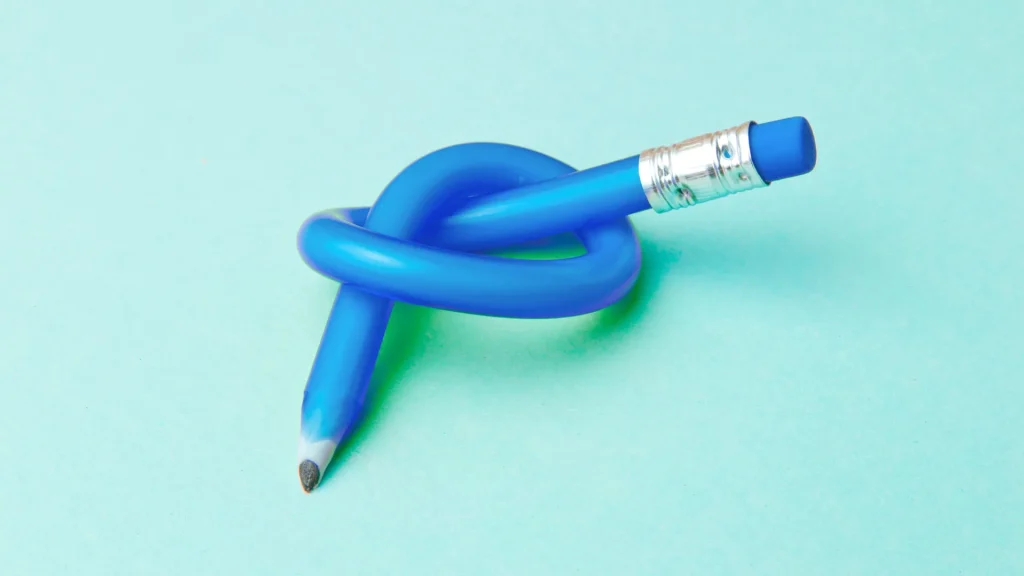 A blue bendy pencil tied into a knot against a light blue background, encouraging the reader visually to embrace flexibility.