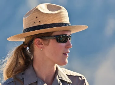 A close up photo of a female national park ranfer with an out of focus background.