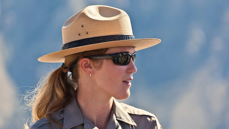 A close up photo of a female national park ranfer with an out of focus background.