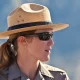 A close up photo of a female national park ranfer with an out of focus background.