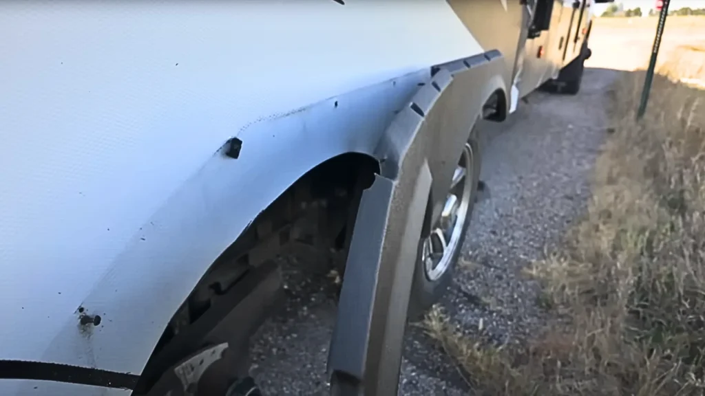 Irene Iron Travels RV, checking out a flapping wheel well cover they noticed whilst driving.