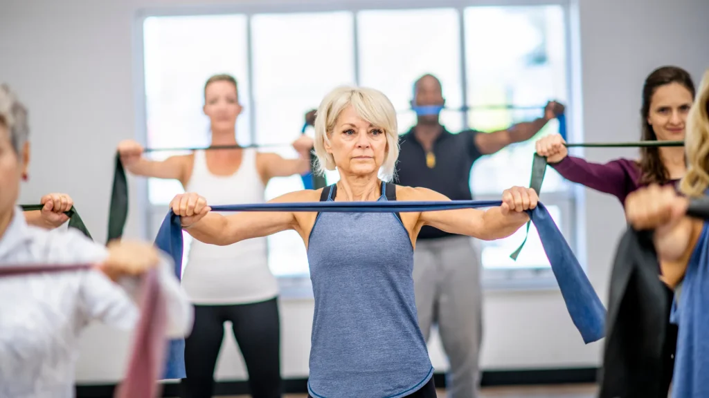 A group class doing strength training with resistance bands. 
