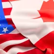 The U.S. flag on the left with the Canadian flag overlapping it on the right.