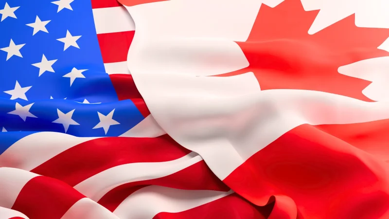 The U.S. flag on the left with the Canadian flag overlapping it on the right.