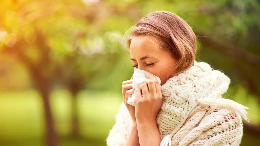 A woman holding a tissue to her nose, emphasizing the fact Rae and Jason were struggling with their allergies in Homer, Alaska. 