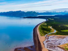 An aerial photo of the bay in Homer, Alaska. SHowcasing the blue waters, deep forests, mountain landscapes, and more.