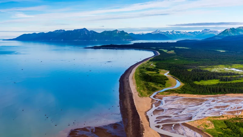 An aerial photo of the bay in Homer, Alaska. SHowcasing the blue waters, deep forests, mountain landscapes, and more.