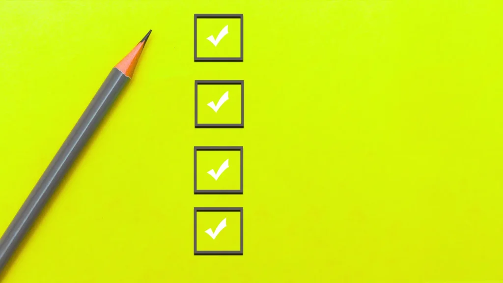 A neon yellow backgrtound with grey check boxes beside a grey pencil as each of the four, vertically aligned, boxes are checked with a white checkmark.