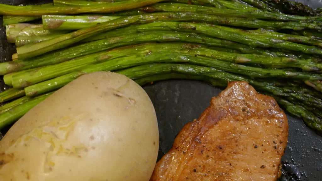 A simple meal of roasted salmon, asparagus and a potato. 