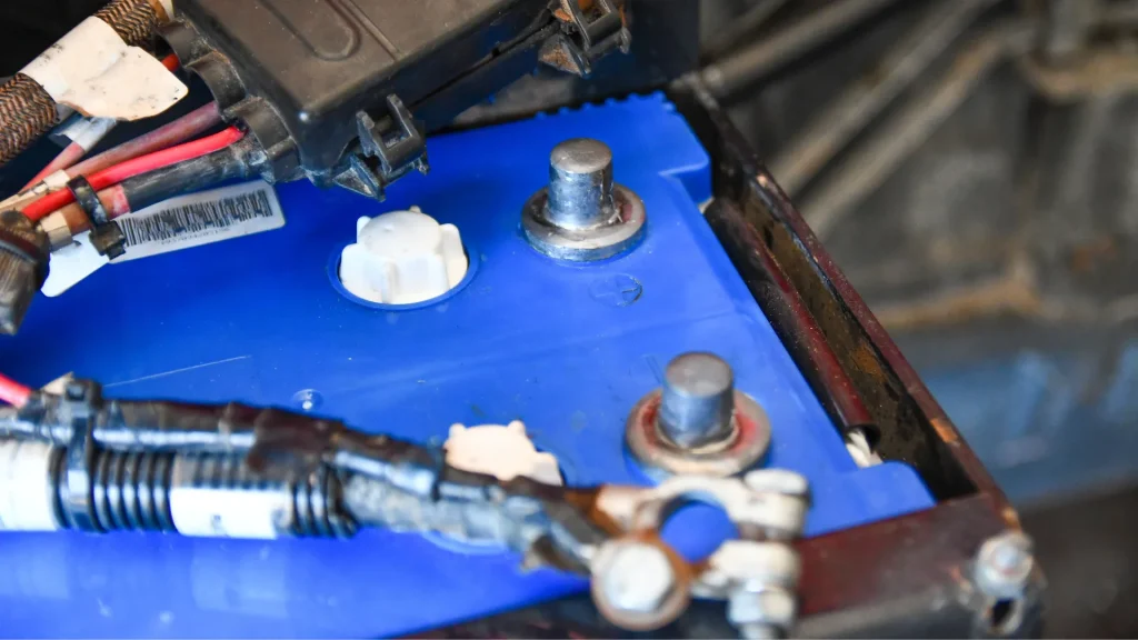 An uplcose photo of a battery and it's casing within a vehicle. 