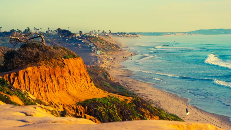 Encinitas Beach in southern California. This photo depicts a sepia toned photograph of bright blue waters and orange cliffs looking out to the ocean.