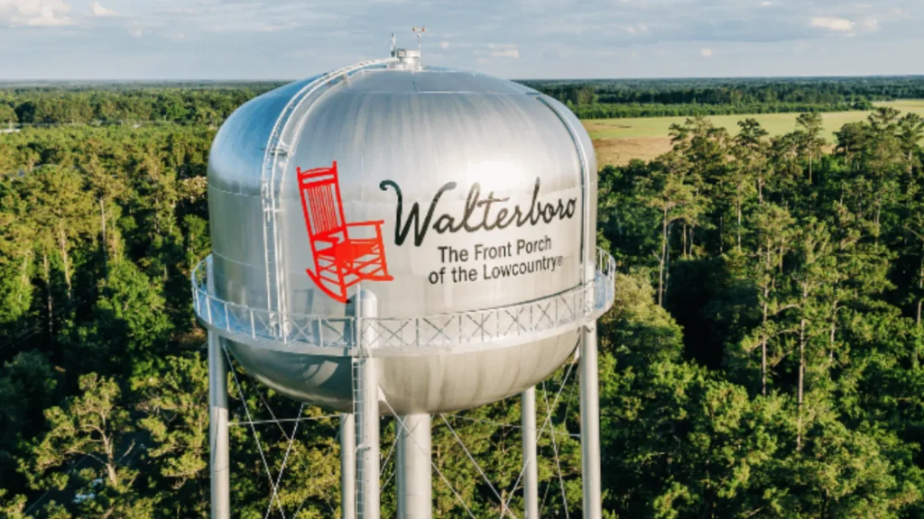 A water tower with a bright red rocking chair painted onto it along with the text "Walterboro The Front Porch of the Lowcountry".