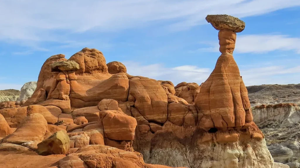 The Grand Staircase-Escalante National Monument as the blue sky behind it contrasts the rusty orange rock formations. 