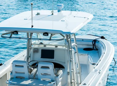 A recreational fishing boat on the ocean driving across the bright blue waters.
