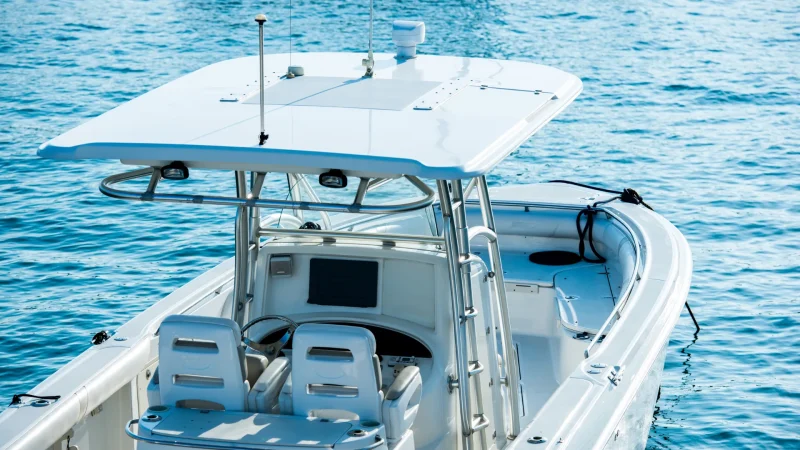 A recreational fishing boat on the ocean driving across the bright blue waters.