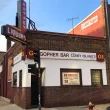 The outside of the Gopher Bar in Minnesota. It's a sunny clear blue sky day in the photo of the brick building.