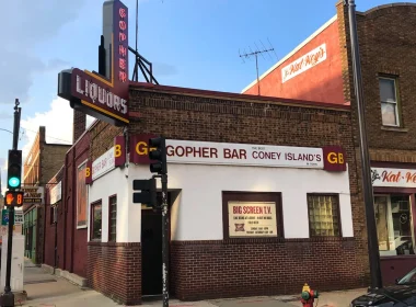 The outside of the Gopher Bar in Minnesota. It's a sunny clear blue sky day in the photo of the brick building.