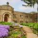 Springtime at Bishop Simon Brute College, Indiana. A historic castle with intricate Christian details amid vibrant gardens.
