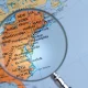 A map showcasing the Eastern coast of the United States with a magnifying glass being held over it.