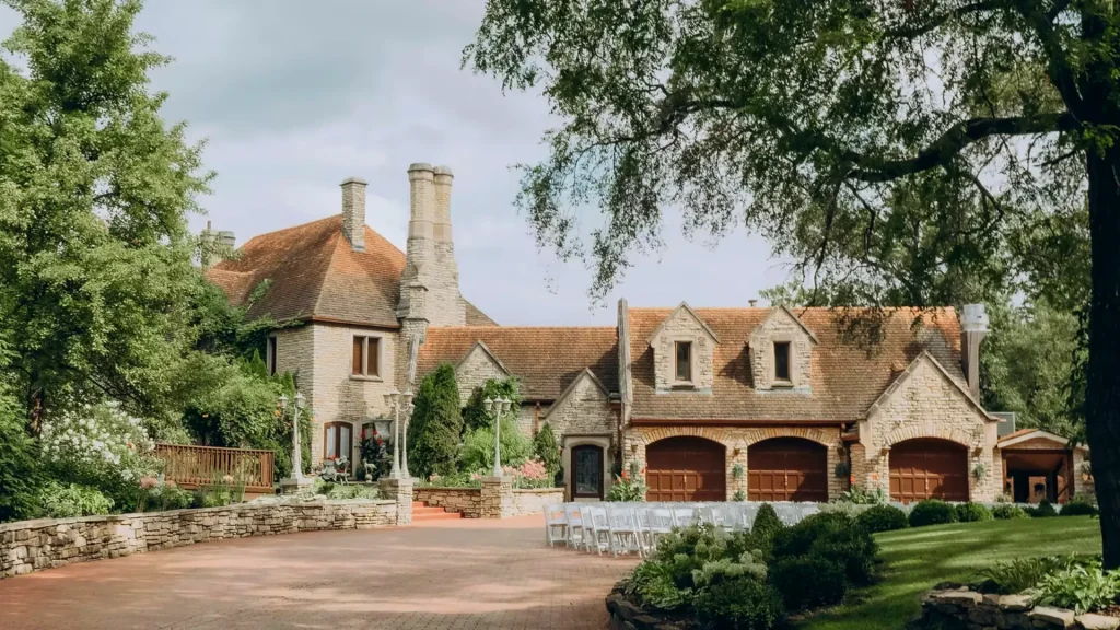 The Meyer's Castle in Indiana. It is a more French-style castle with warm-toned stone castle with an orange colored roof. The lawn is manicured perfectly around it. 