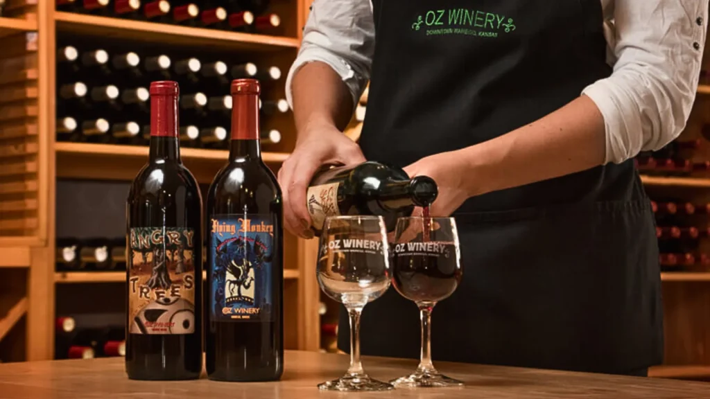 A staff person pouring one of the red wines offered by OZ Winery into a wine glass.